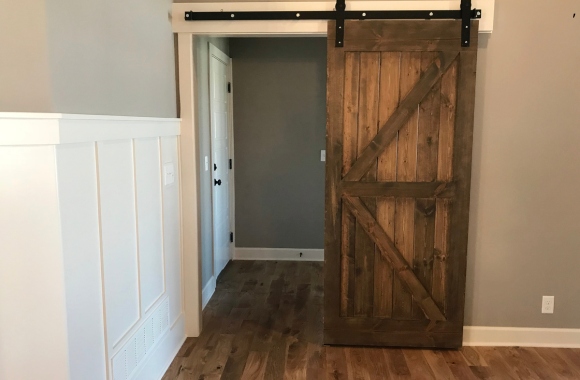 Puerta de interior corredera tipo granero en madera natural instalada en pasillo — CarpiMarket